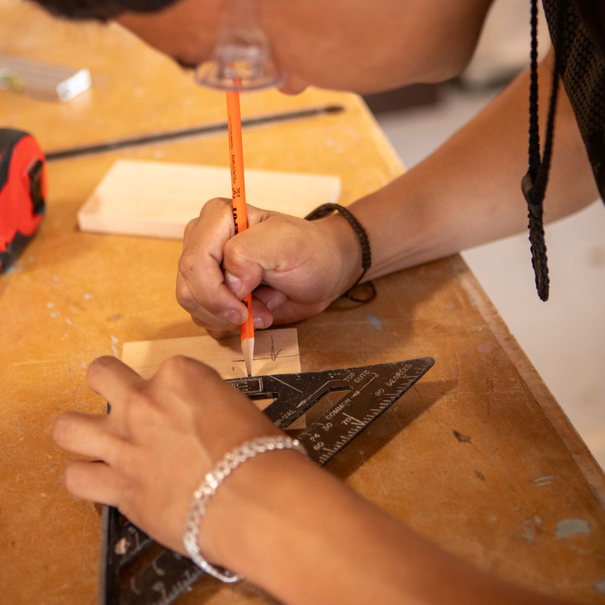 Pencil marking a timber piece against a square