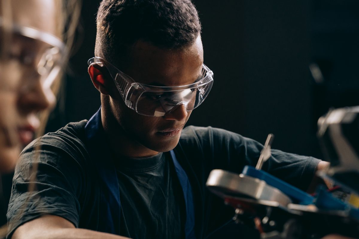 A person wearing clear protective safety glasses in a workshop