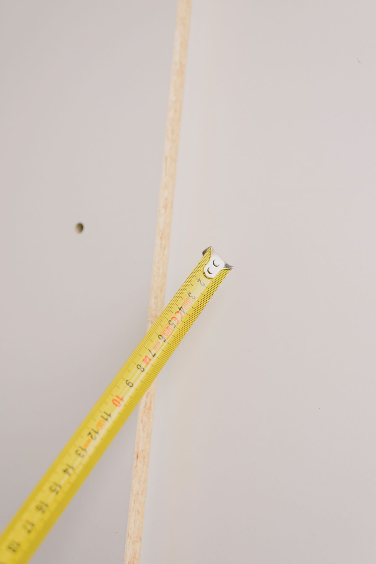 A tape measure positioned against an indoor timber edge