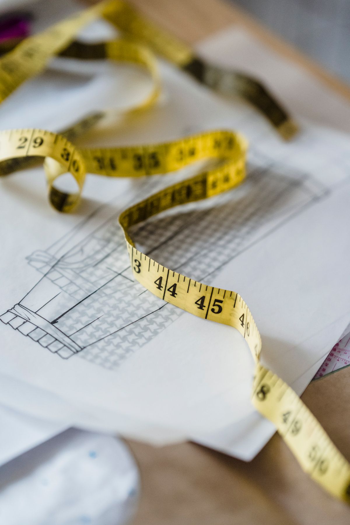 A tape measure resting on a dimensioned drawing