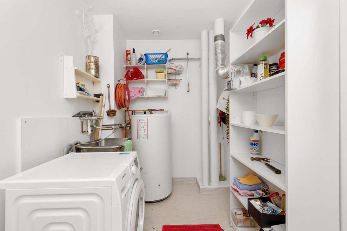 Utility area with shelves above a washing machine