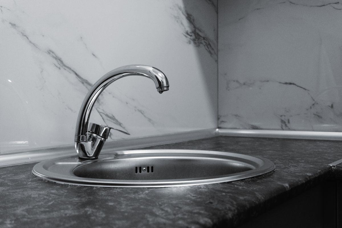 A stainless-steel sink and tap showing the metal finish