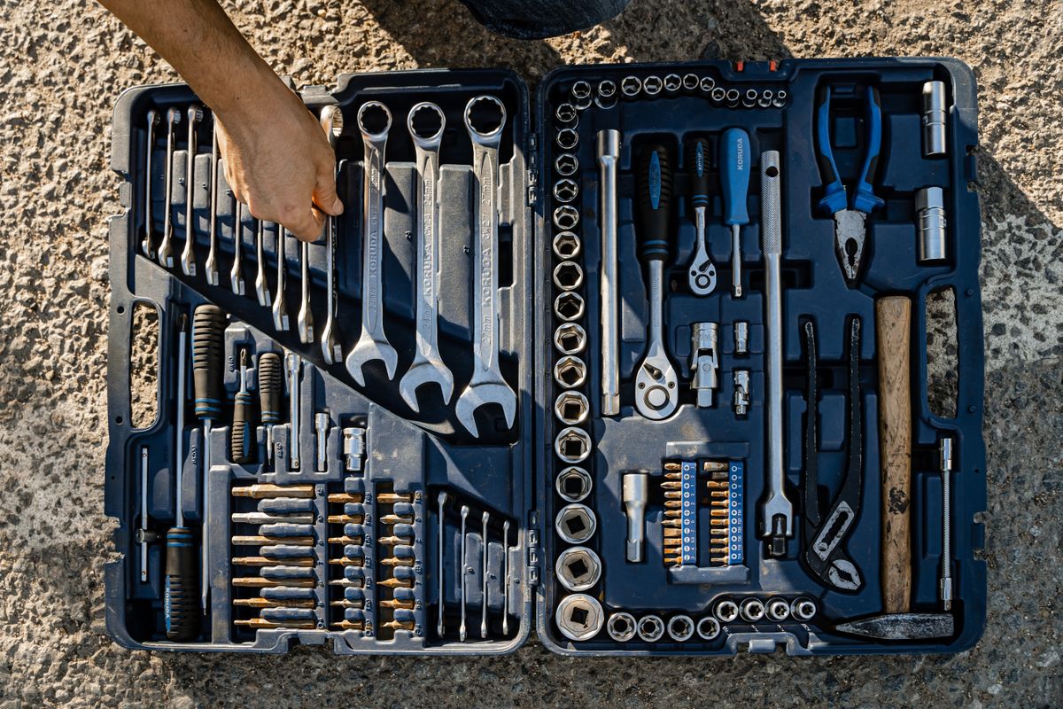 An open case with hand tools arranged in fitted compartments