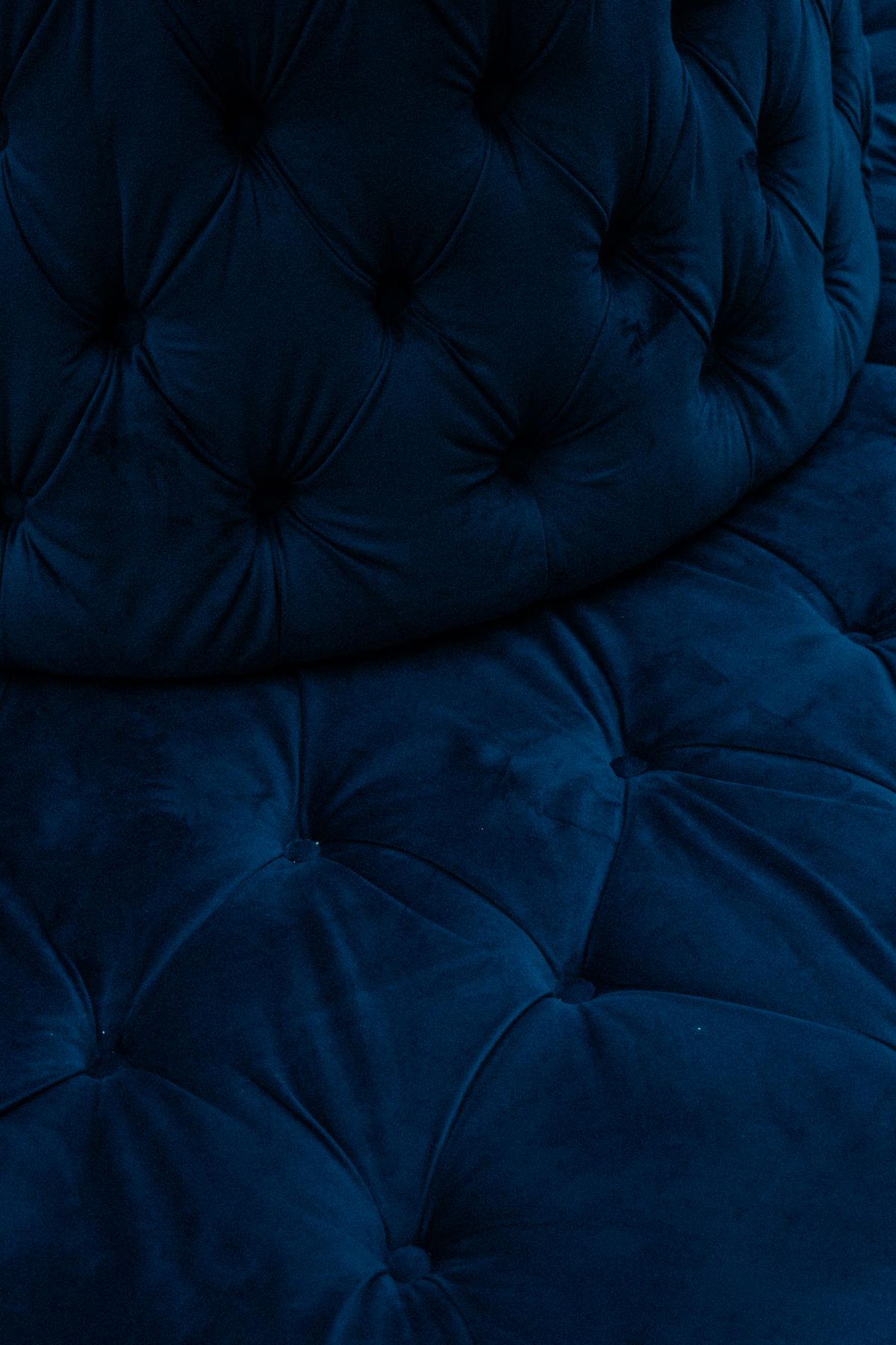 Close-up of the texture and seams of a blue upholstered sofa